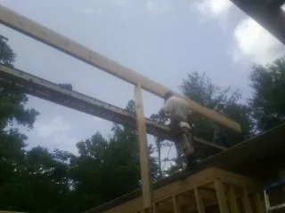 Carpenter setting a ridge beam over a new addition frame — Ice Dam Removal by Roofing Brothers in Platte City
