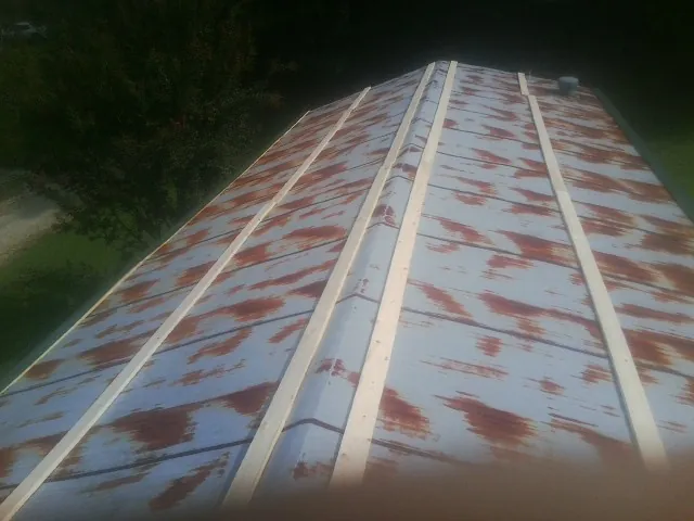 Rusted metal roof panels with new wood purlins before replacement — Storm Damage Roof Repair in Platte City by Roofing Brothers