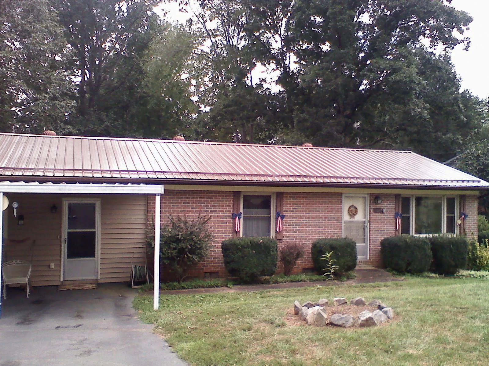 Bronze metal roof and carport on a brick ranch home — Roof Repair work by our crew in Platte City