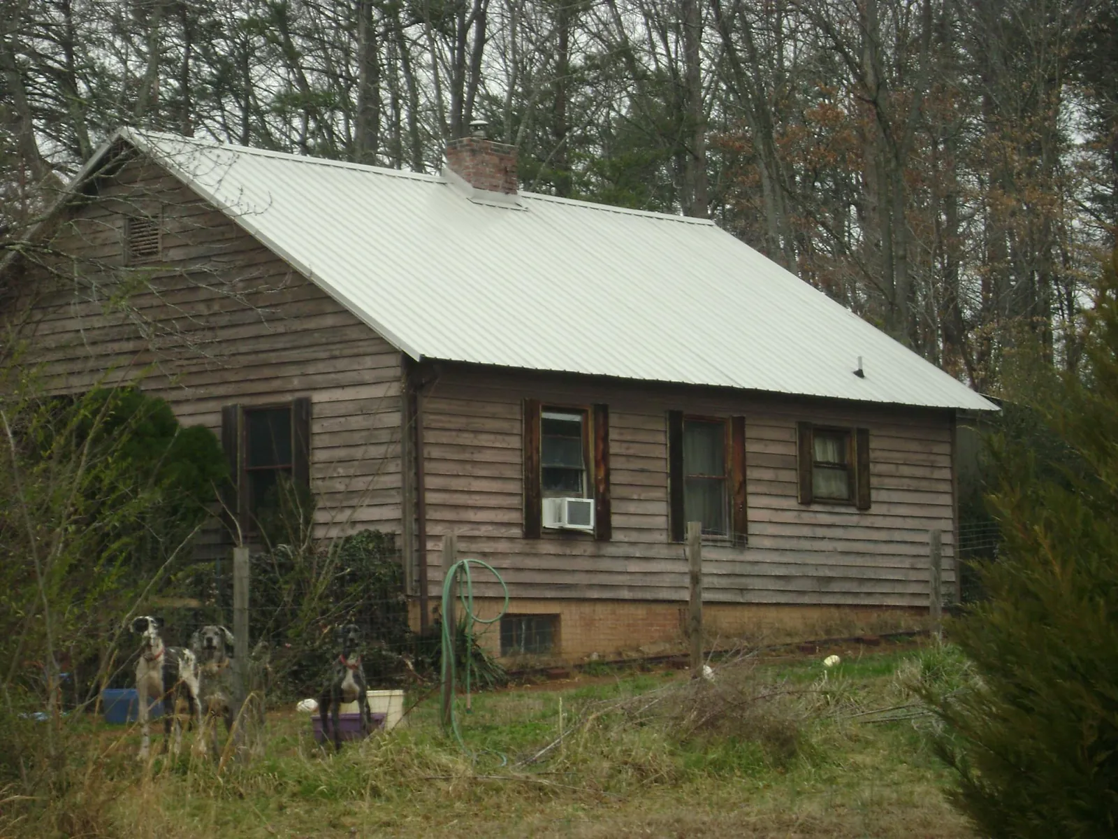 White metal roof on an old wood sided farmhouse, from a Metal Roof Installation job in Platte City
